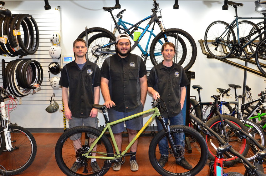 From left, Alex Rewun, 40; Paul Rodriguez, 26; and Brian Shuey, 37, the three owners and managers of The Bicycle Shack in Arvada, stand April 7 at their shop. Colorado’s stay-at-home order deemed a long list of industries “critical” — meaning employees in those sectors can still come to work — and bicycle repair shops are on that list.